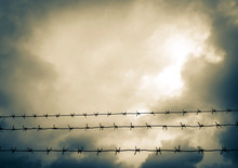Barbed Wire And A Stormy Sky.