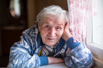 Wall Mural - Closeup portrait of elderly woman sitting at the table.