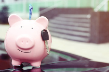 Poster - Piggy money box with cash and key on car bonnet at the street