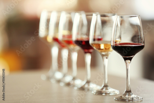 Fotografía Many glasses of different wine in a row on a table