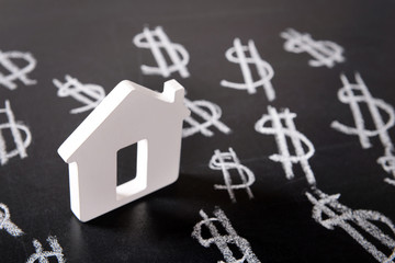 House figure and painted dollar symbols on chalkboard,closeup