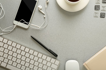 Wall Mural - Workplace with mobile phone, peripheral devices and stationery on grey table