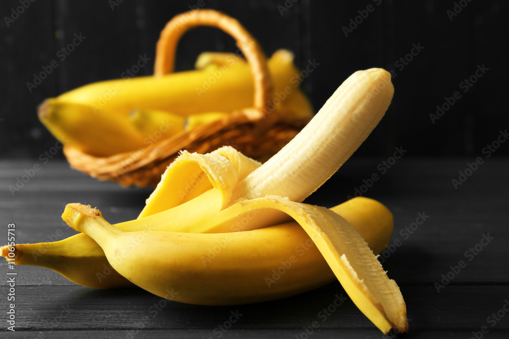 Half peeled banana on dark wooden background