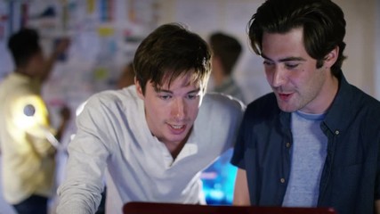  Group of young male computer programmers working together in small office