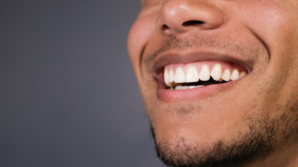 healthy teeth of a male as he smiles at something, space for text