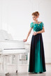 © Mike Orlov - Beautiful young attractive woman in dress playing white piano