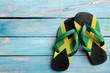 Thongs with flag of Jamaica, on blue wooden boards