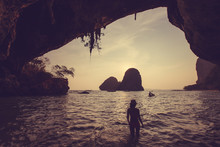 Silhouette Of A Girl In A Cave On The Beach At Sunset In Thailan