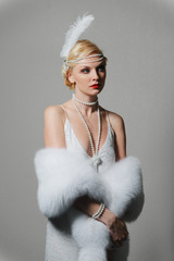 woman in white dress with shoulder straps and long fur stole