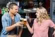 © WavebreakmediaMicro - Cute couple toasting with beers