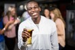 © WavebreakmediaMicro - Smiling man showing a beer with his friends