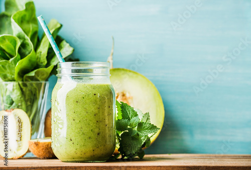 Cuadros en Lienzo Freshly blended green fruit smoothie in glass jar with straw
