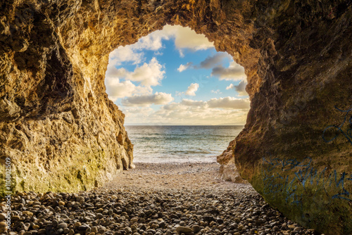 Fotografie, Obraz Watching the sunset on the ocean from a cave