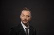 © Svyatoslav Lypynskyy - Portrait of happy smiling businessman looking at camera in studio. Young man posing for photographer isolated on grey background.