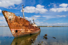 Old Ship Run Aground And Rusting In The Shore. Seixal, Portugal.