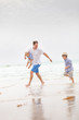 © goodmoments - Portrait of father with two sons walking on the ocean beach. Summer vacations by the sea. Outdoors. Happy family.