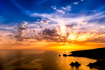 Dramatic sunset over Aphrodite's Rock also known as Rock of the