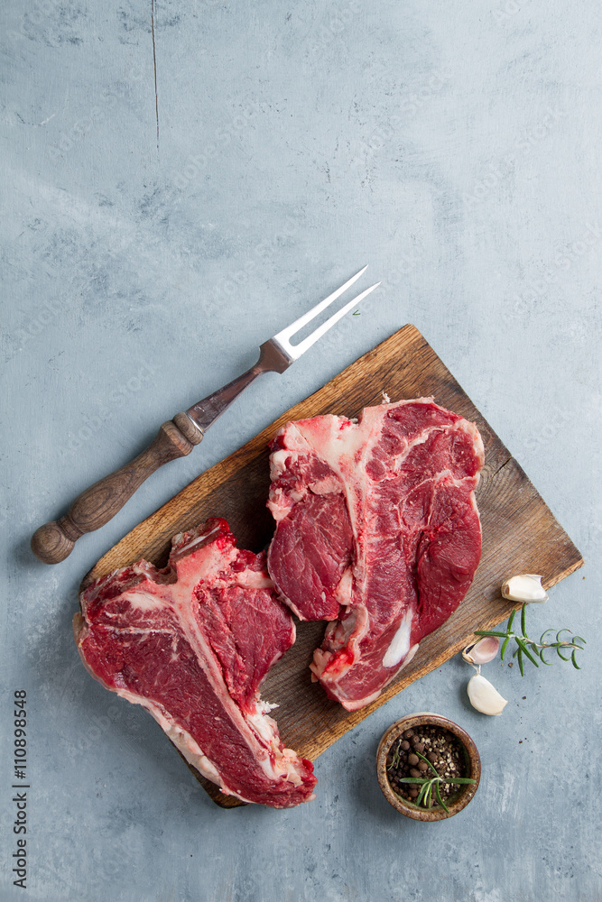 Thick raw T-bone steak with seasoning - obrazy, fototapety, plakaty 