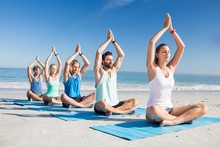 People Doing Yoga On The Beach