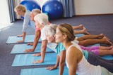 Seniors and fitness instructor stretching their legs