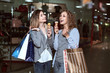 © mikhail_kayl - Beautiful girls with eating ice cream. Fashion Shopping two ladies Portrait. Beauty Woman with Shopping Bags in Shopping Mall. Shopper. The concept of good mood and fun. Shopping Center