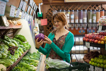 Mid Adult Woman Selecting Red Cabbage In Health Food Store