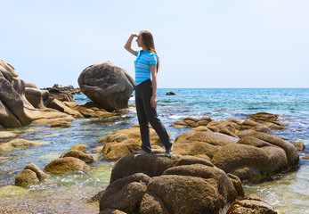 Wall Mural - girl is standing on the sea stone