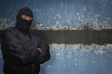 Wall Mural - dangerous man in a mask standing near a wall with painted national flag of botswana