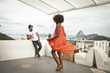 © Connect Images - Woman dancing on terrace, Sugarloaf Mountain in background, Rio, Brazil