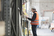 © Connect Images - Young male warehouse worker searching shelves with clipboard in warehouse