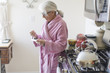 © Connect Images - Senior woman in bathrobe in kitchen