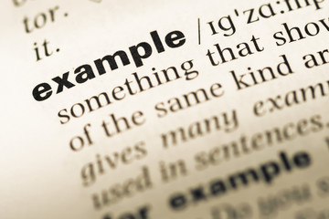 close up of old english dictionary page with word example