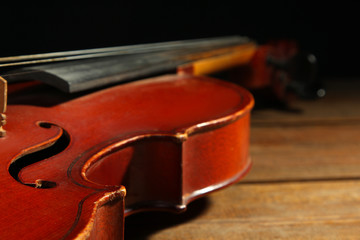 violin on wooden brown background closeup