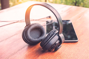 earphones and tablet on wooden