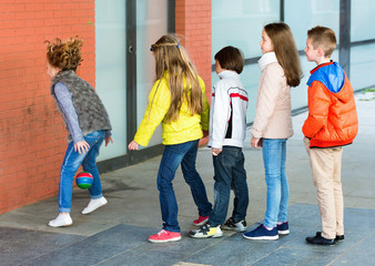 Wall Mural - Group of children throwing ball to wall and jumping over