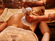 © Gennadiy Poznyakov - Woman having ayurvedic massage with back pouch of rice. Close up of exotic India massage.