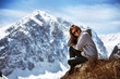 Beautiful girl sits on mountain backdrop