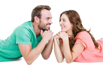 Wall Mural - Happy young couple lying on floor looking to each other 