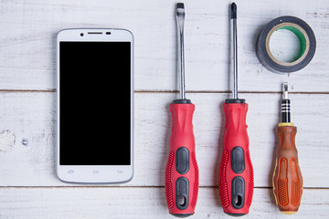 smartphone and equipment repair on the white wooden background.