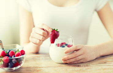 Wall Mural - close up of woman hands with yogurt and berries