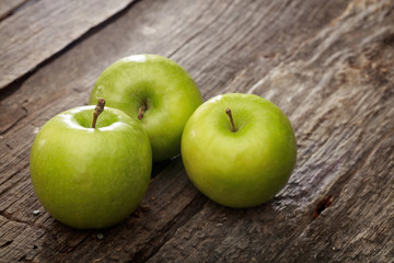 Wall Mural - Green apples, on wooden surface.