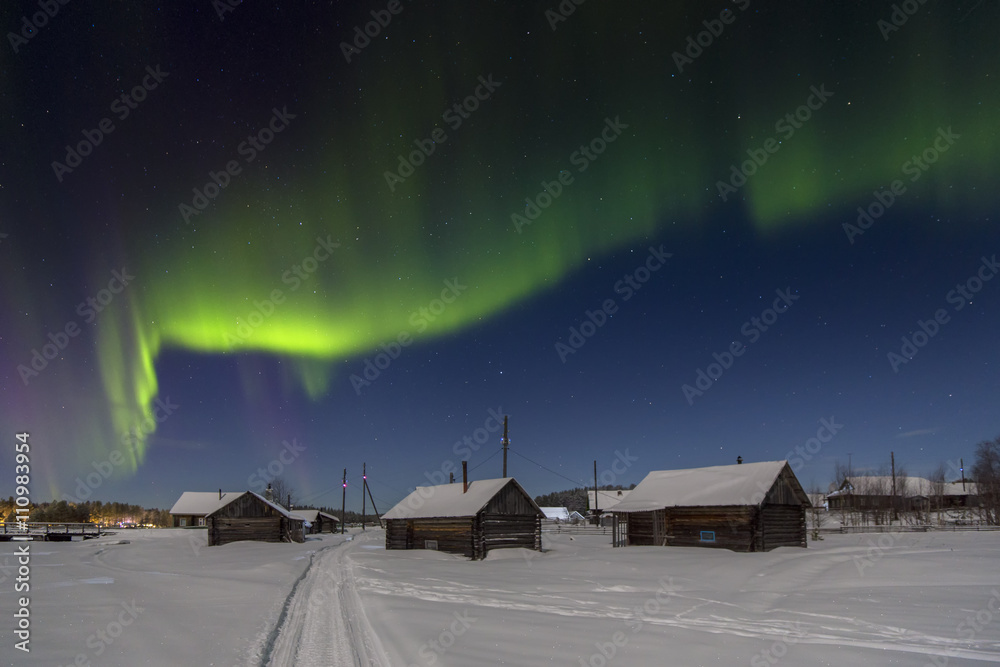 Village house in the lights of moon and Aurora borealis. Northern ...
