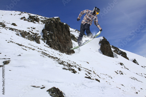 Cuadros en Lienzo Corredor de snowboard que salta sobre las montañas