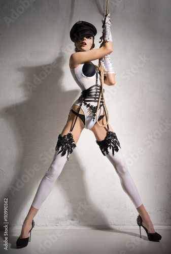 Fotografia Girl in sexual Police clothes hanging on a rope