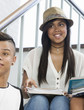 © Connect Images - Students on steps, discussing over textbook