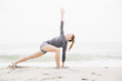 © Connect Images - Mid adult woman meditating on beach, rear view