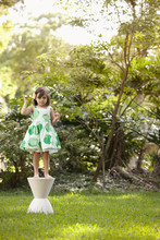 Young Girl In Garden, Standing On Pedestal