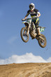 © Connect Images - Young male motocross racer jumping muddy hill