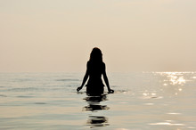Girl Silhouette At Sunset In The Water At Seaside