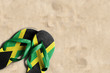 Thongs with flag of Jamaica, on beach sand
